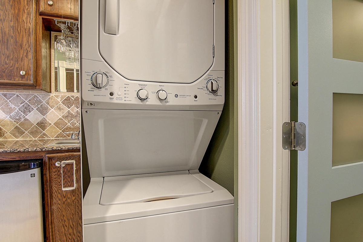 Your in-unit washer and dryer stack makes laundry effortless during your stay, tucked conveniently between the kitchen and living areas.