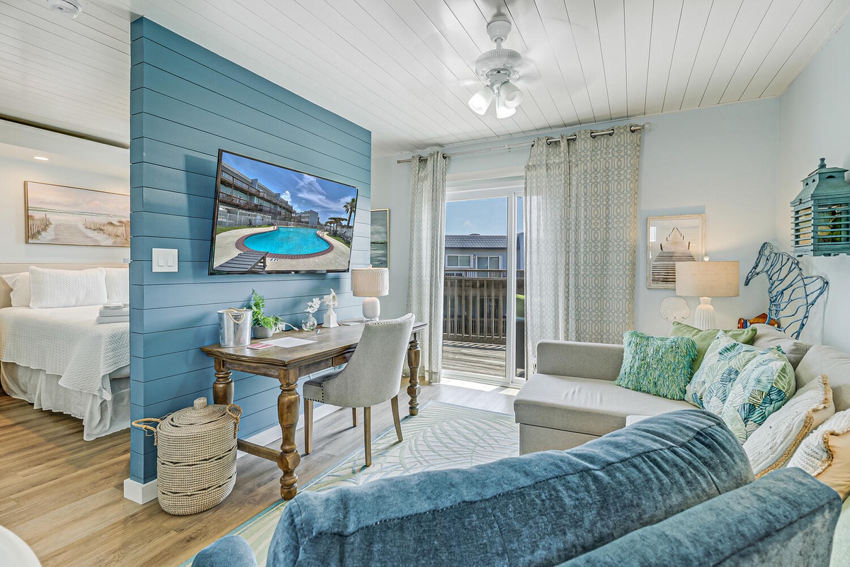 Relax in your coastal-inspired living space with soothing blues, comfy seating, and a private balcony overlooking the community.