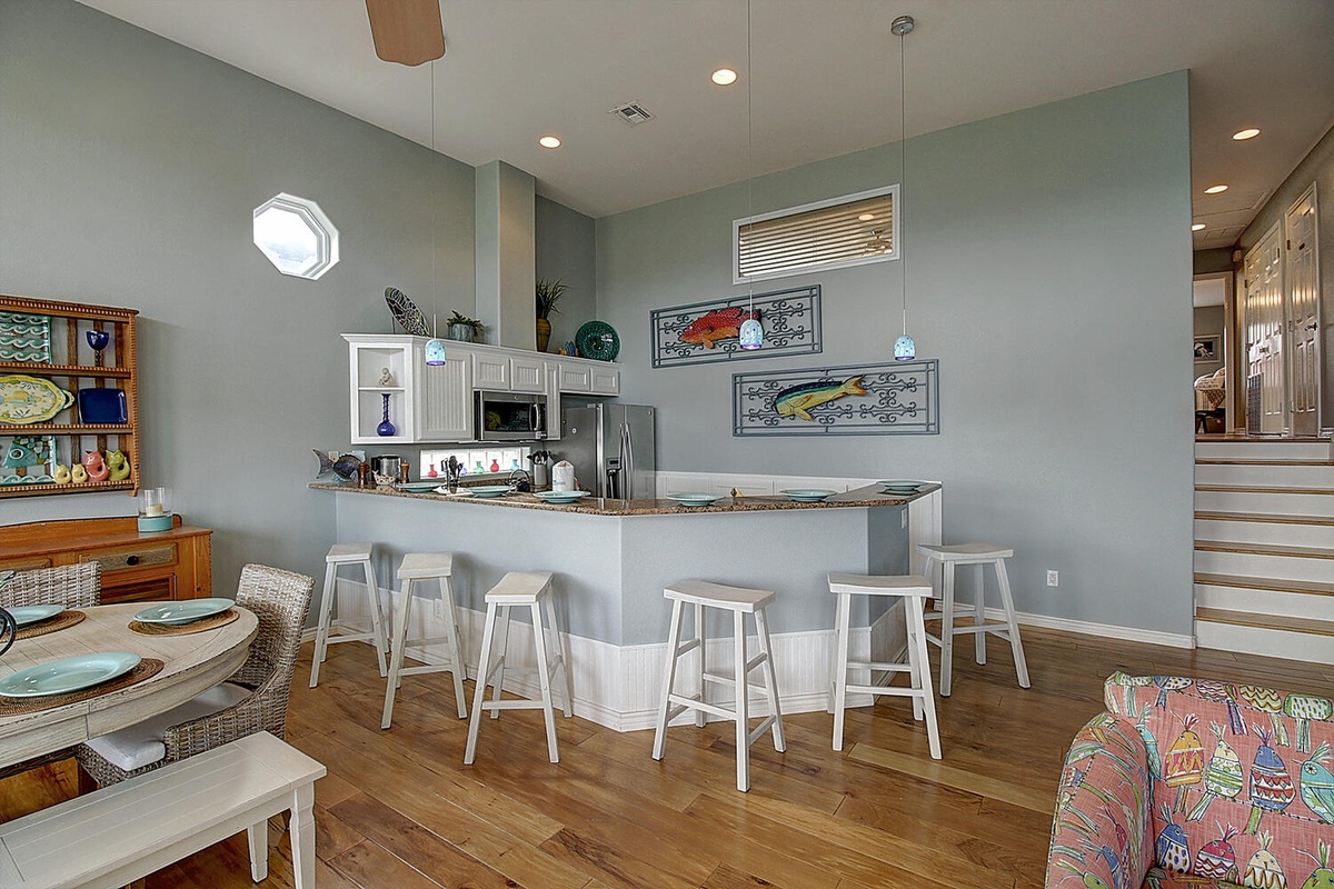 Your spacious kitchen features granite countertops, modern appliances, and coastal-inspired art, perfect for preparing meals with friends and family.