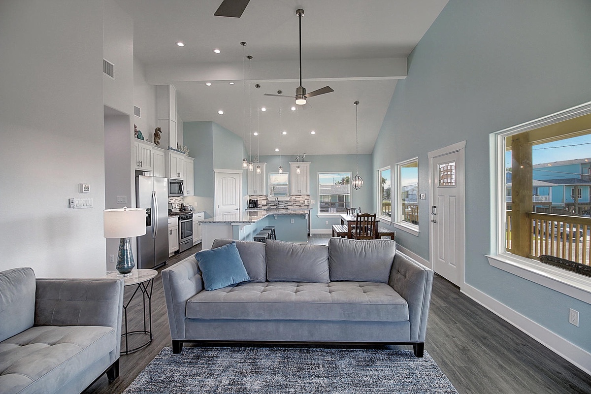 Relax in your spacious living room with soaring ceilings, modern coastal colors, and an open kitchen perfect for preparing meals together.