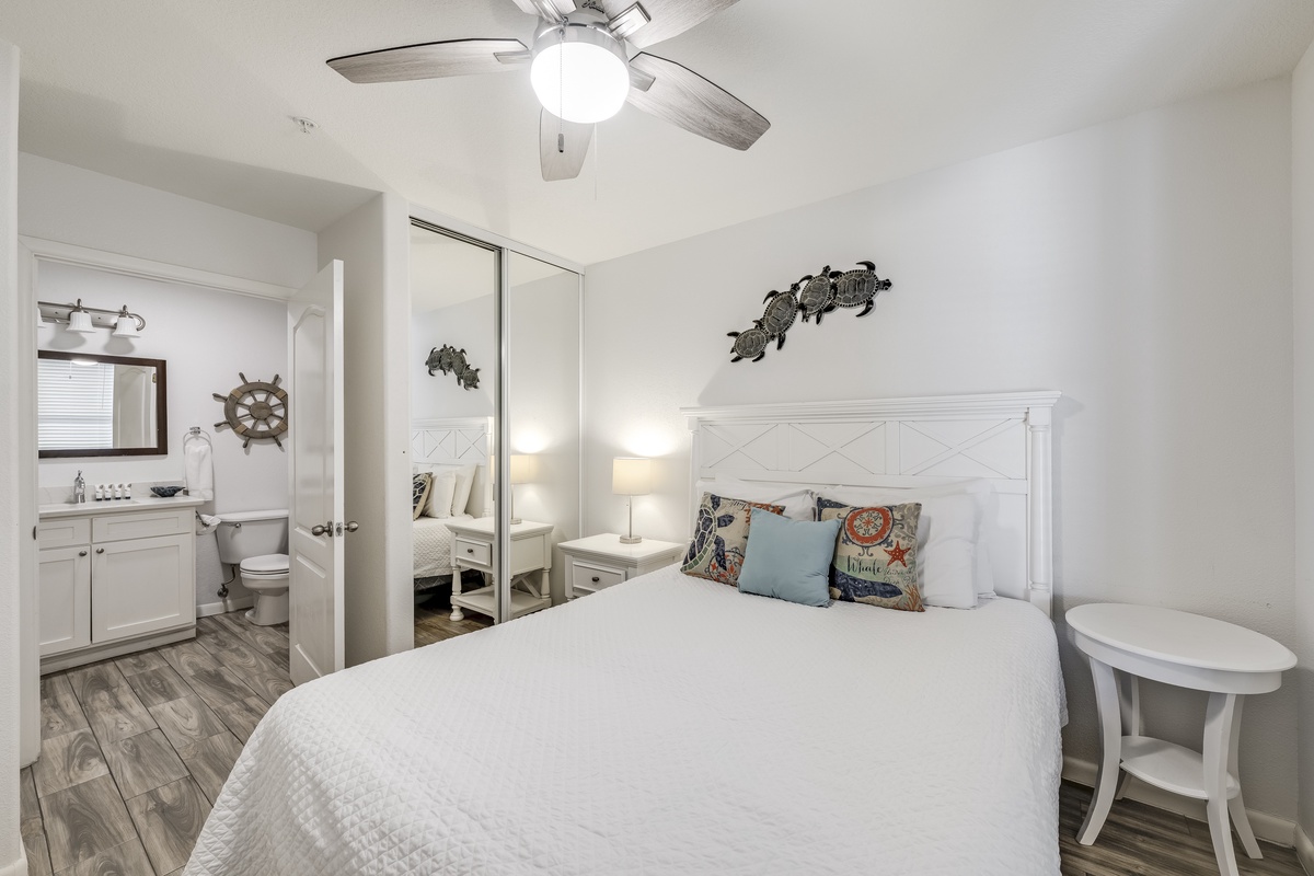 Unwind in this coastal-inspired bedroom, where crisp white linens and nautical touches create your perfect retreat. The ceiling fan keeps you cool, while the en-suite bath adds convenience to your stay.