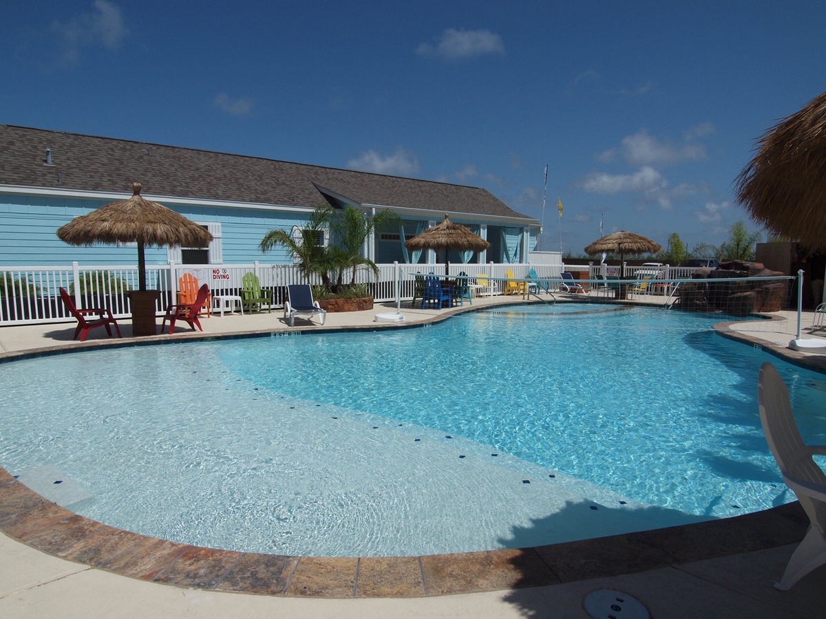 Dive into crystal-clear waters surrounded by tropical thatched umbrellas and colorful lounge chairs for your perfect poolside retreat.
