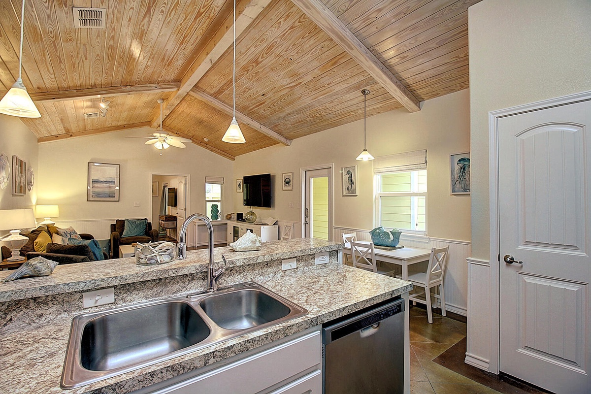 Your open-concept kitchen flows into the living space, featuring granite countertops and warm wood ceilings for memorable meal prep.