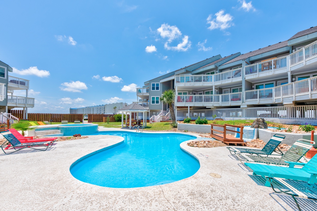 Sparkling pool surrounded by colorful loungers where you can soak up the sun and unwind in this beautifully landscaped courtyard setting.