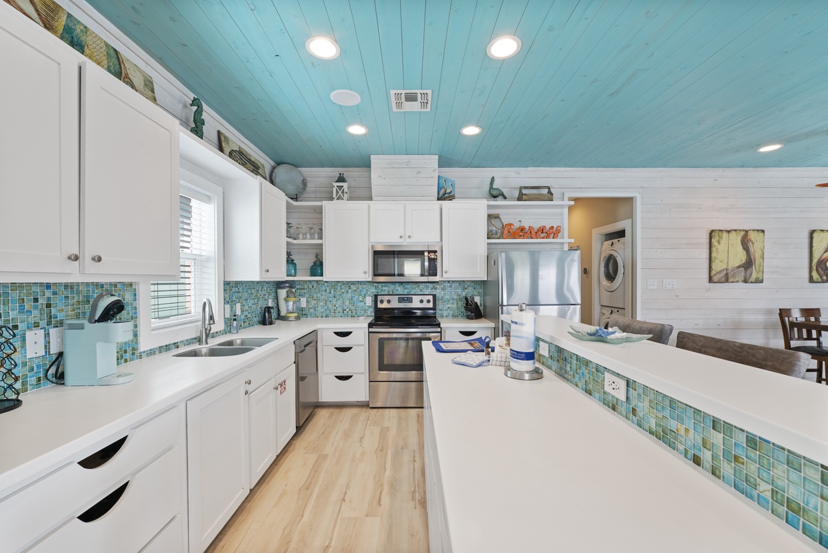 Step into your coastal-inspired kitchen, where aqua ceilings and ocean-hued backsplash tiles set a breezy, beachy mood. Stainless appliances and bright white counters give you all the space you need to prepare favorite meals.