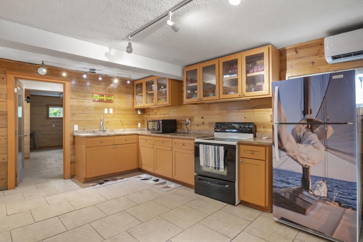 Third well equipped kitchen with granite countertops, modern appliances, and warm wood cabinetry.