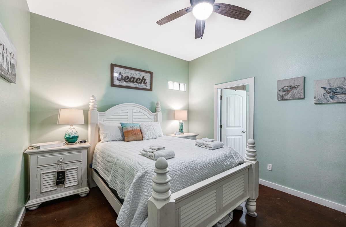 Drift into peaceful sleep in your coastal-themed bedroom with soft sage walls and beach-inspired decor creating a tranquil retreat.