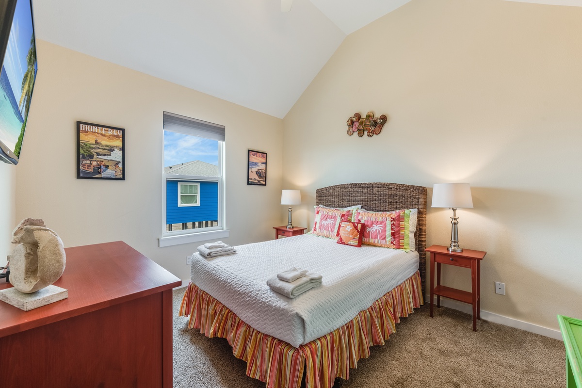 Rest peacefully in this charming bedroom where coastal artwork and fresh towels await your arrival.