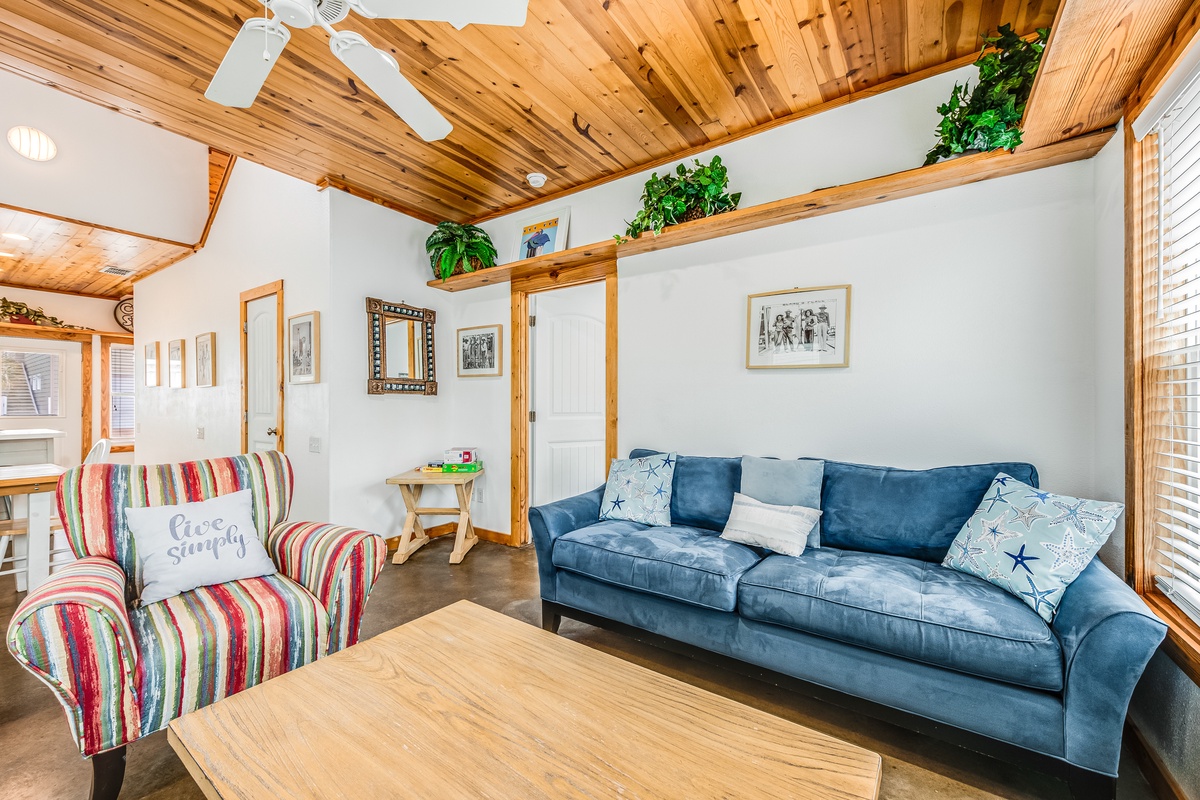 Unwind in this charming living room where rustic wood beams meet coastal comfort, creating your perfect retreat.