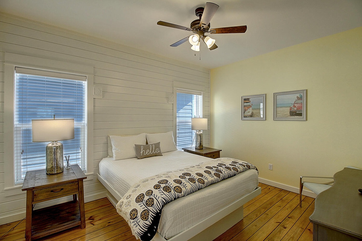 Rest in your serene bedroom with crisp linens, warm wood floors, and charming shiplap walls that whisper coastal comfort.