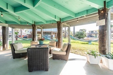 Relax in your sunlit outdoor living space with wicker seating overlooking the waterfront—perfect for morning coffee or sunset drinks.