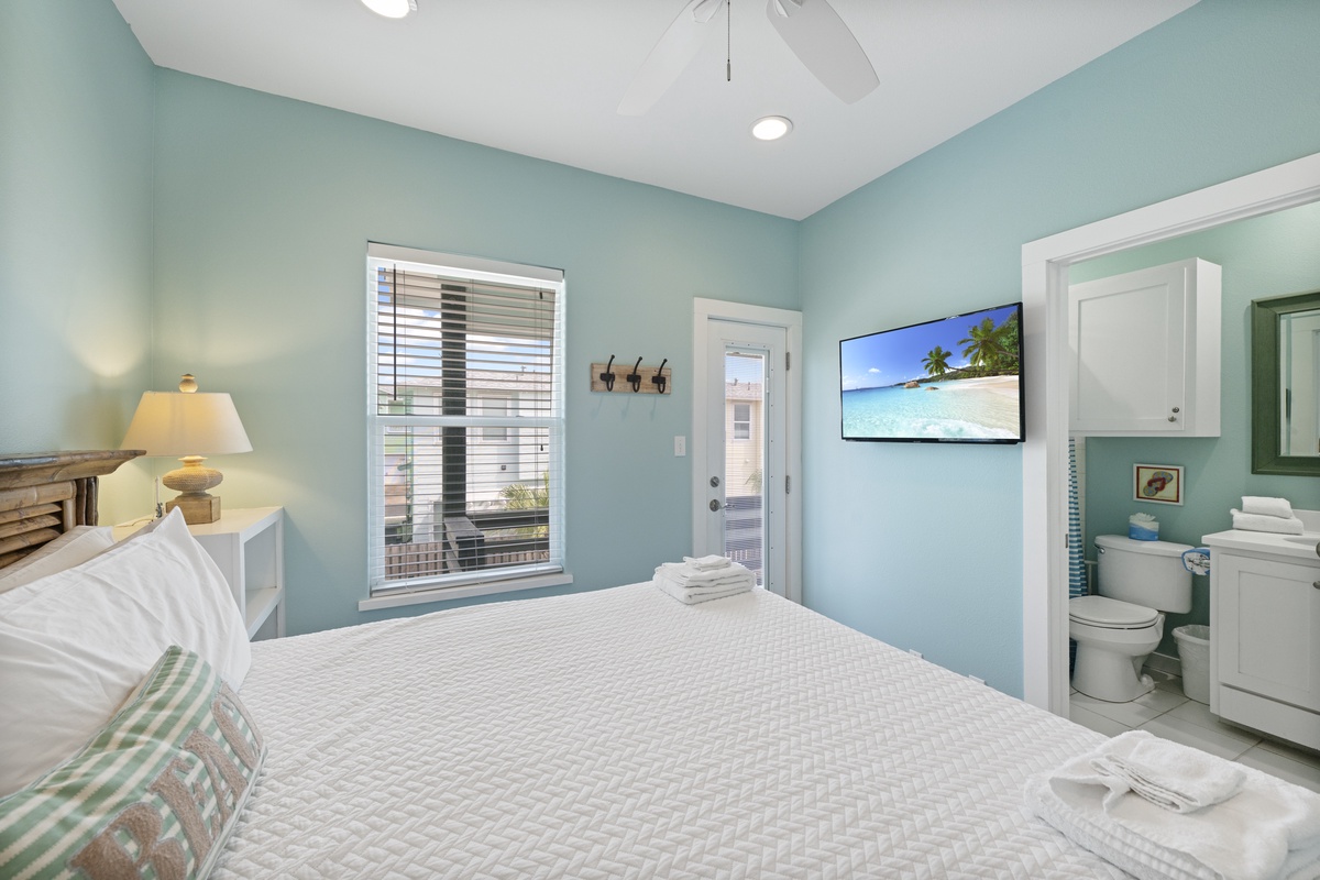 Drift off in your serene coastal bedroom, wrapped in soft linens and cooled by the ceiling fan overhead. The soft aqua walls and gentle lighting create a tranquil retreat where you can unwind after a day of exploring.