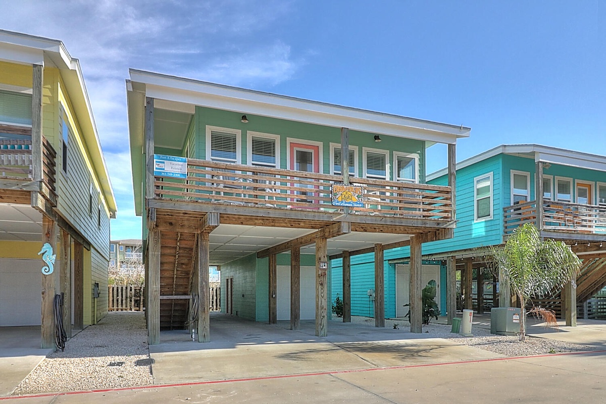 Colorful beachside rental homes with elevated porches and coastal charm in a vibrant vacation community.