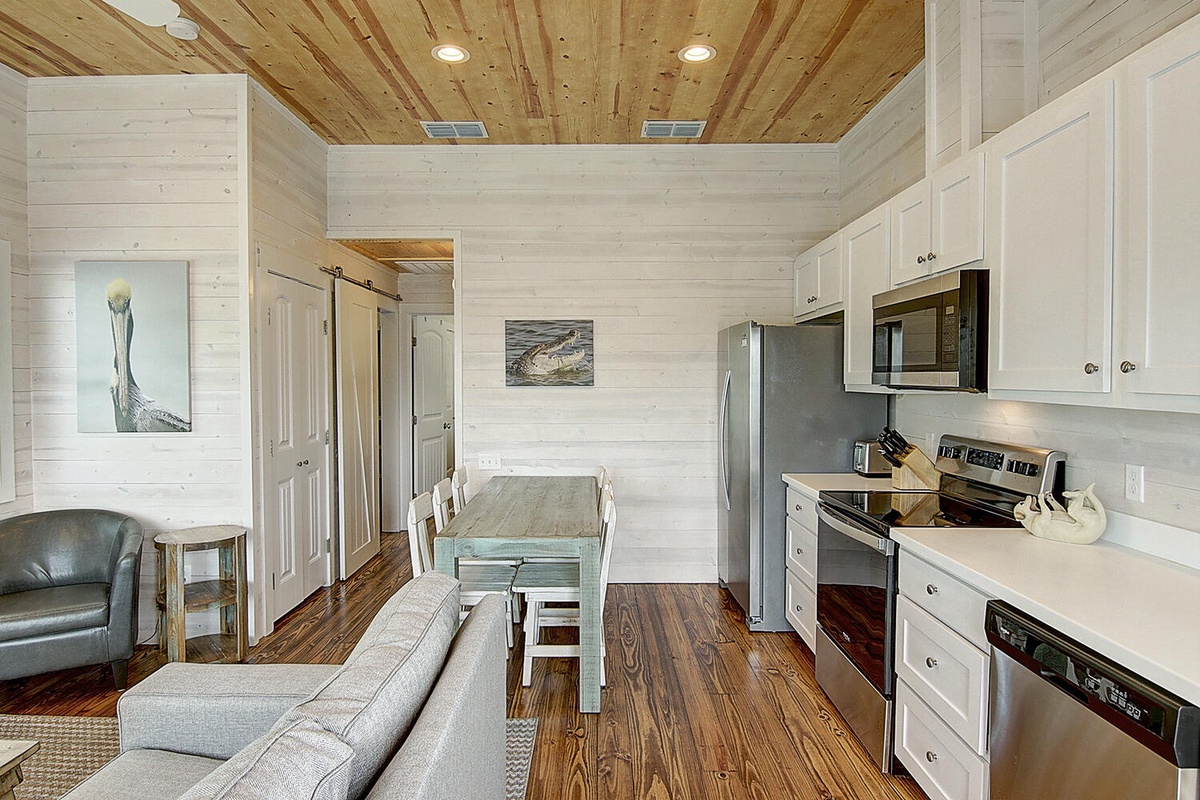Your open-concept retreat combines rustic wood ceilings with sleek modern appliances, creating a perfectly balanced space for cooking and relaxation.