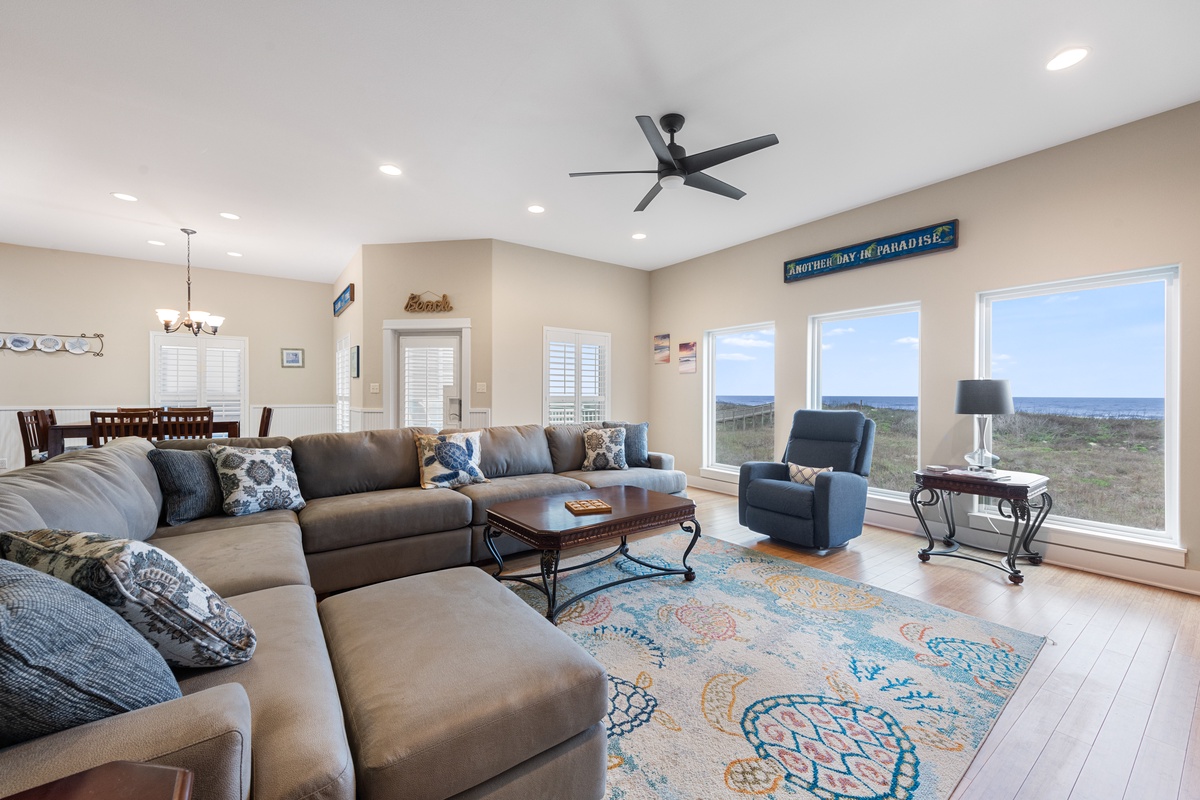 Unwind in your spacious living room where panoramic windows frame endless views and coastal breezes flow through open spaces.