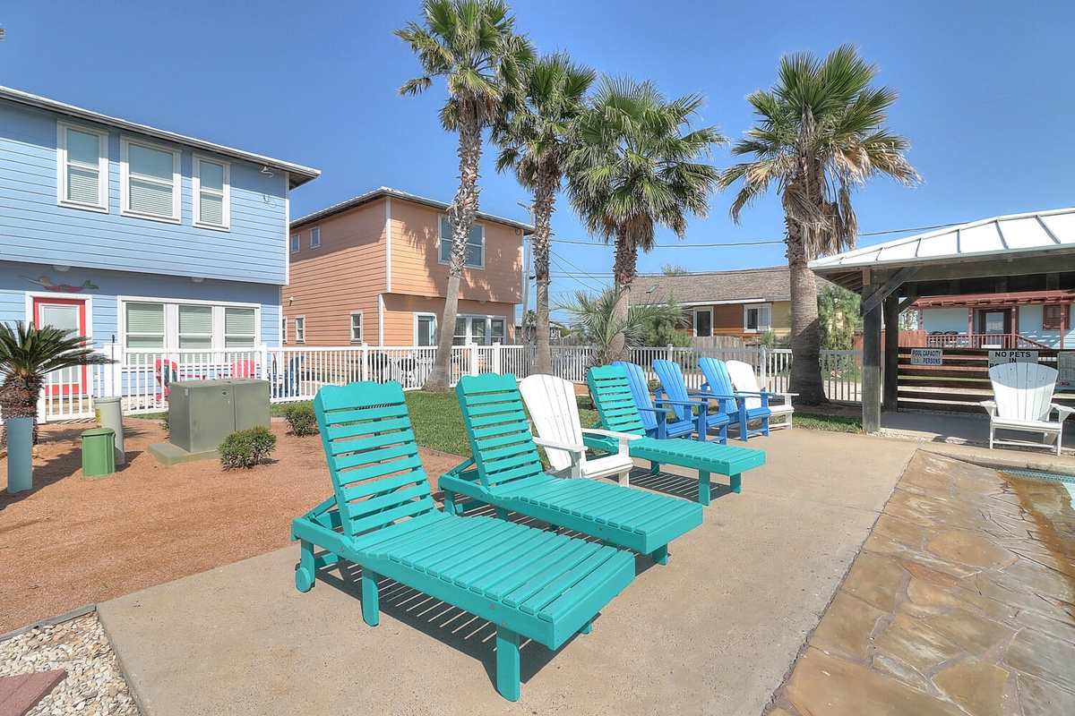 Unwind on colorful loungers under swaying palms, where tropical vibes meet coastal comfort in this inviting outdoor retreat.