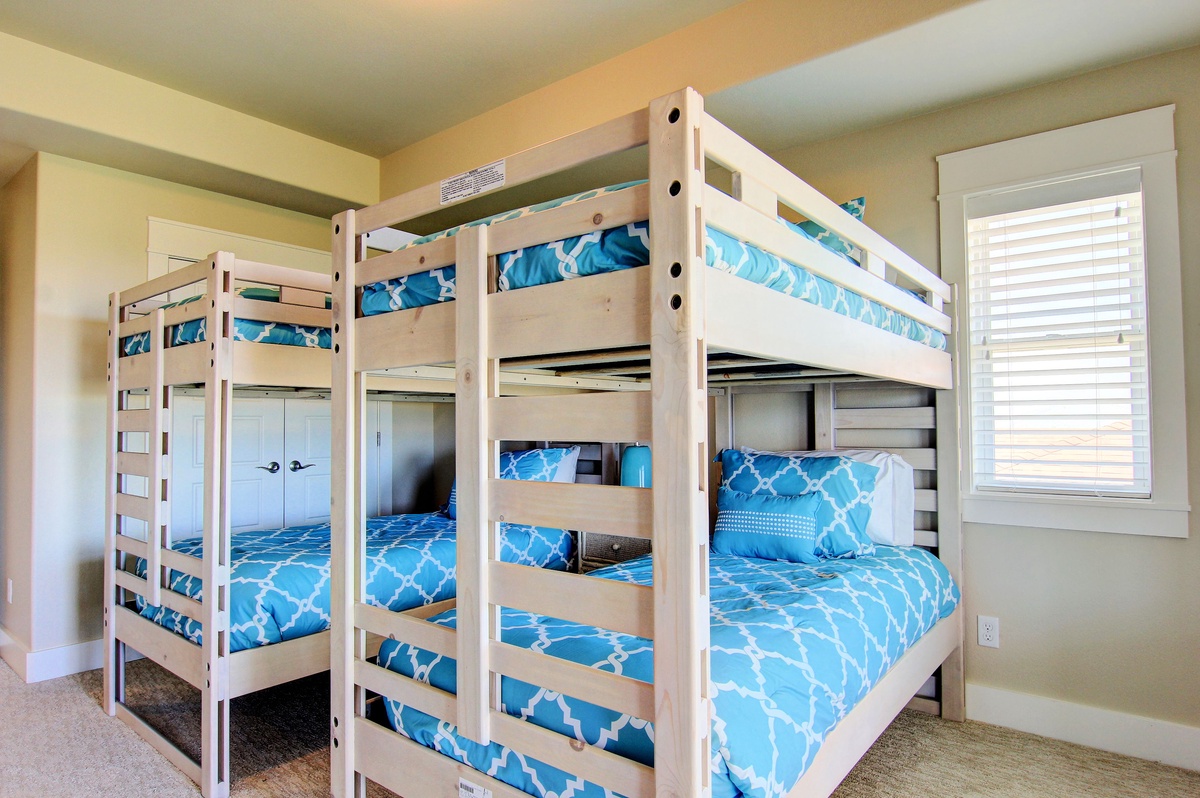 Your family's perfect sleep sanctuary with sturdy bunk beds dressed in cheerful blue linens, creating cozy retreats for restful nights.