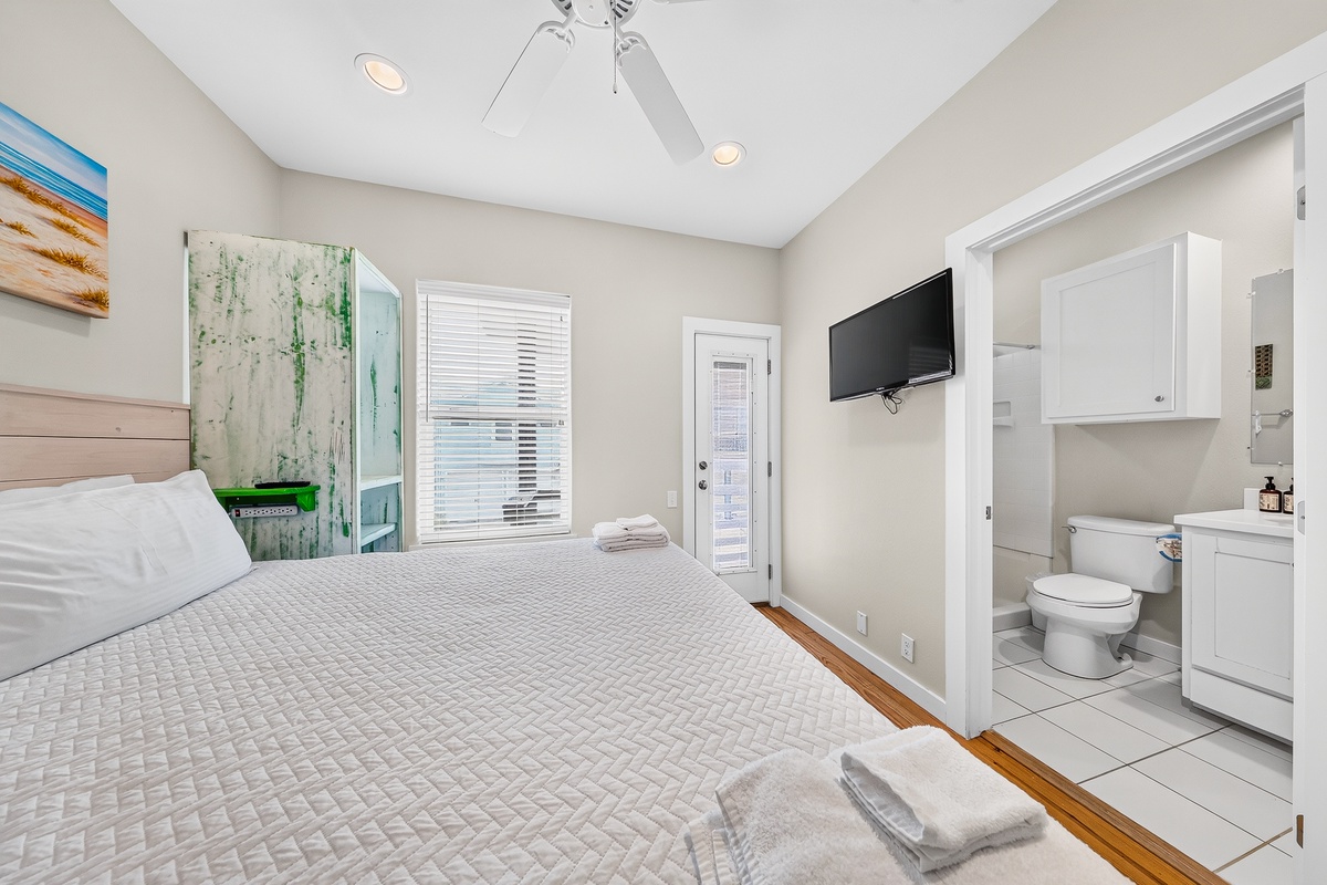 Your cozy primary bedroom features coastal-inspired décor, comfortable bedding, and a wall-mounted TV for relaxing evenings.