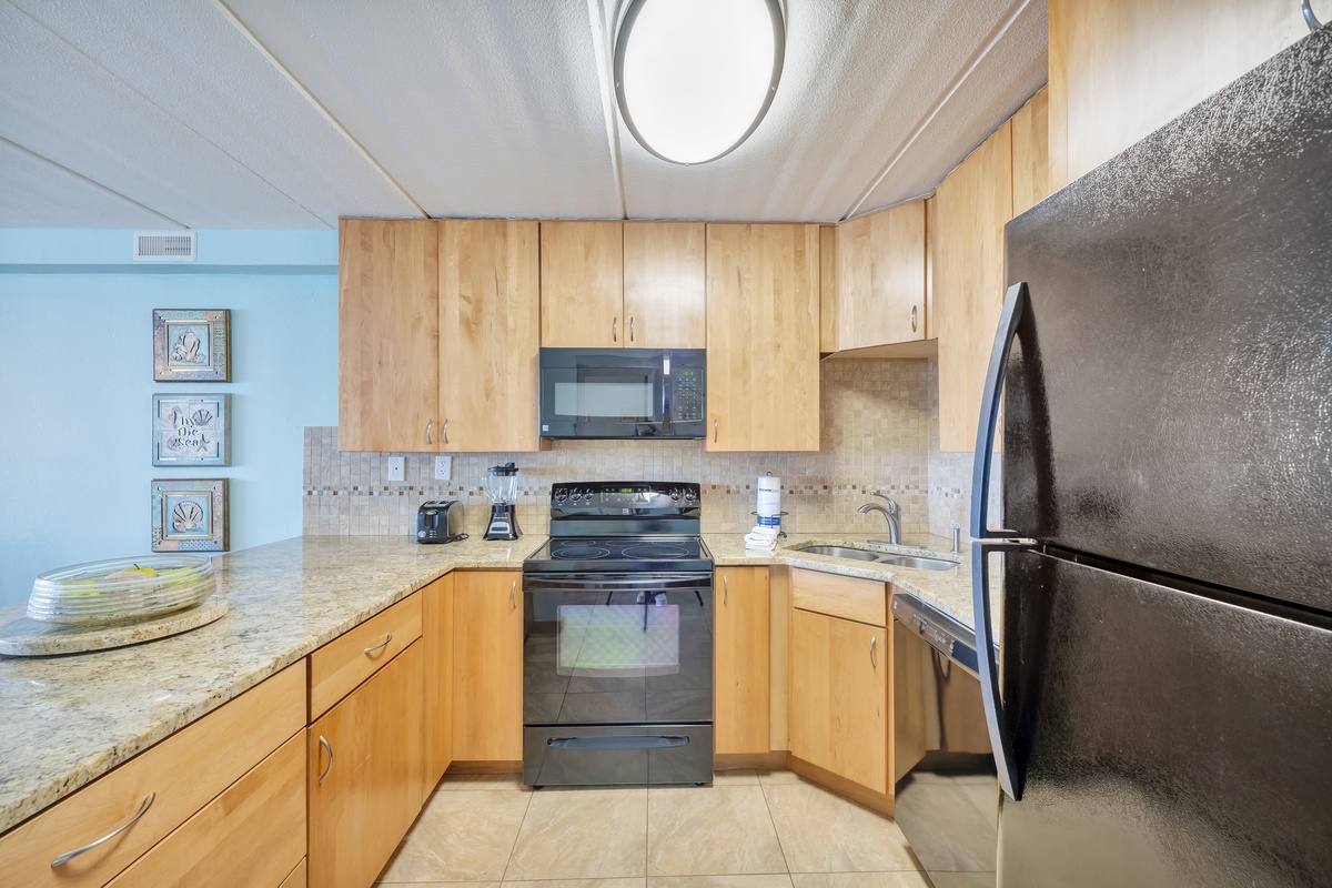 Your fully equipped kitchen awaits with granite countertops, stainless steel appliances, and warm wood cabinets—perfect for preparing memorable meals during your stay.