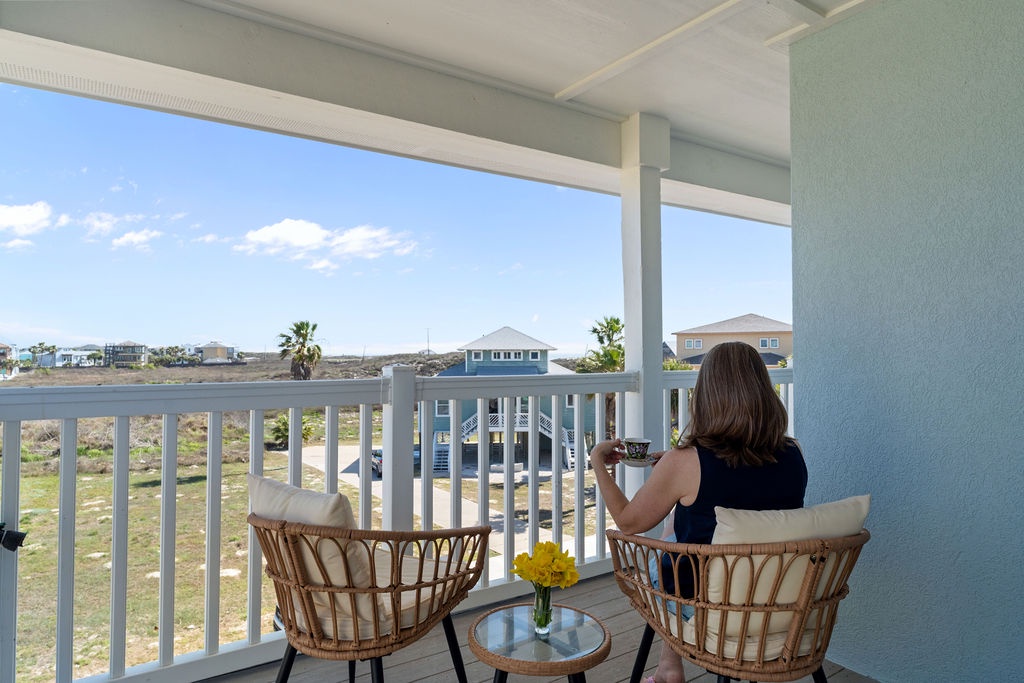 Sip your morning coffee from these cozy wicker chairs while watching the coastal neighborhood come alive below your private balcony.