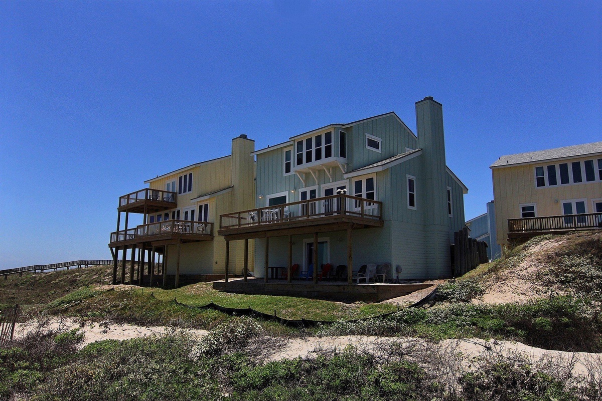 Beachfront property with multiple decks and direct beach access through natural dune landscape.