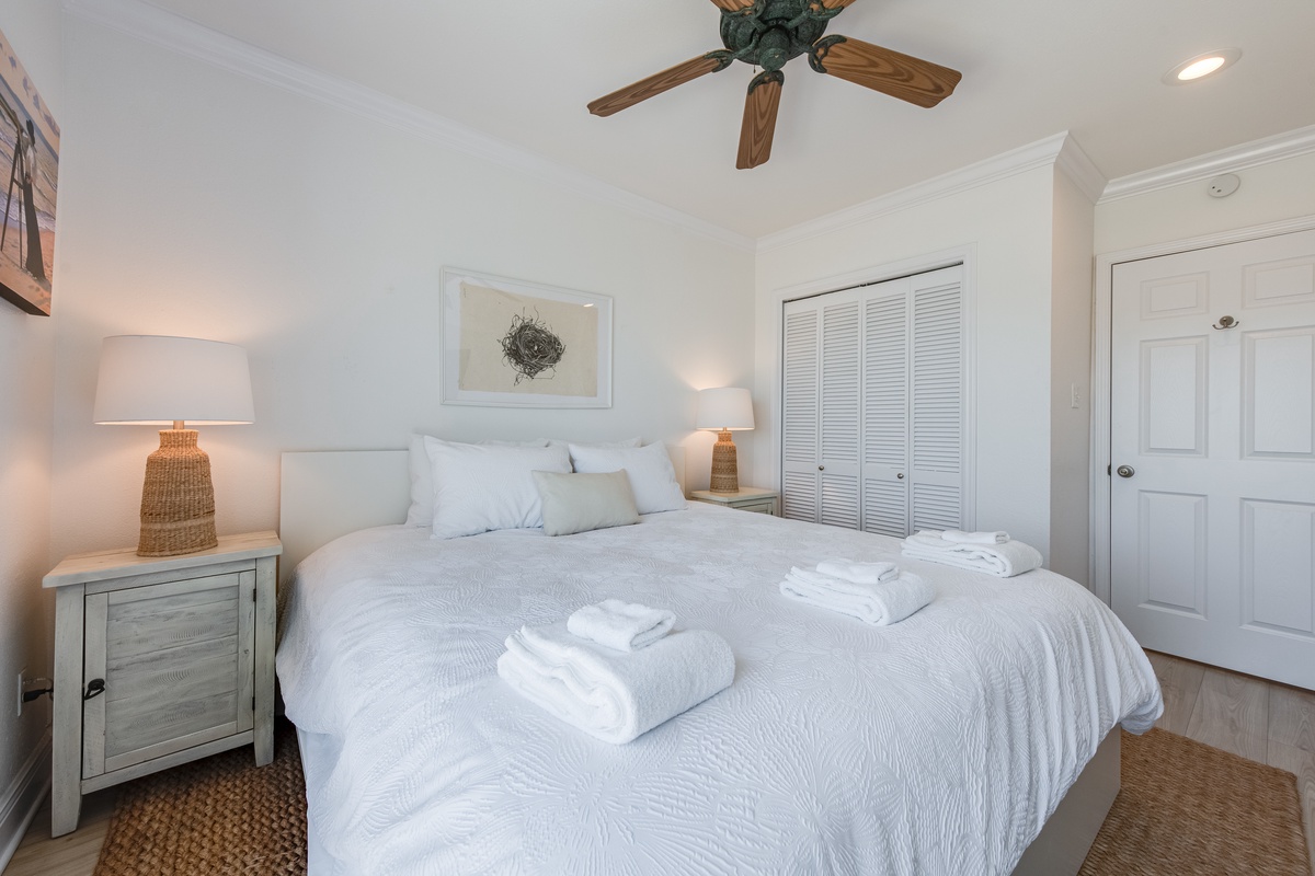 Sink into crisp white linens and coastal charm in your serene bedroom retreat with soft lighting and thoughtful touches.