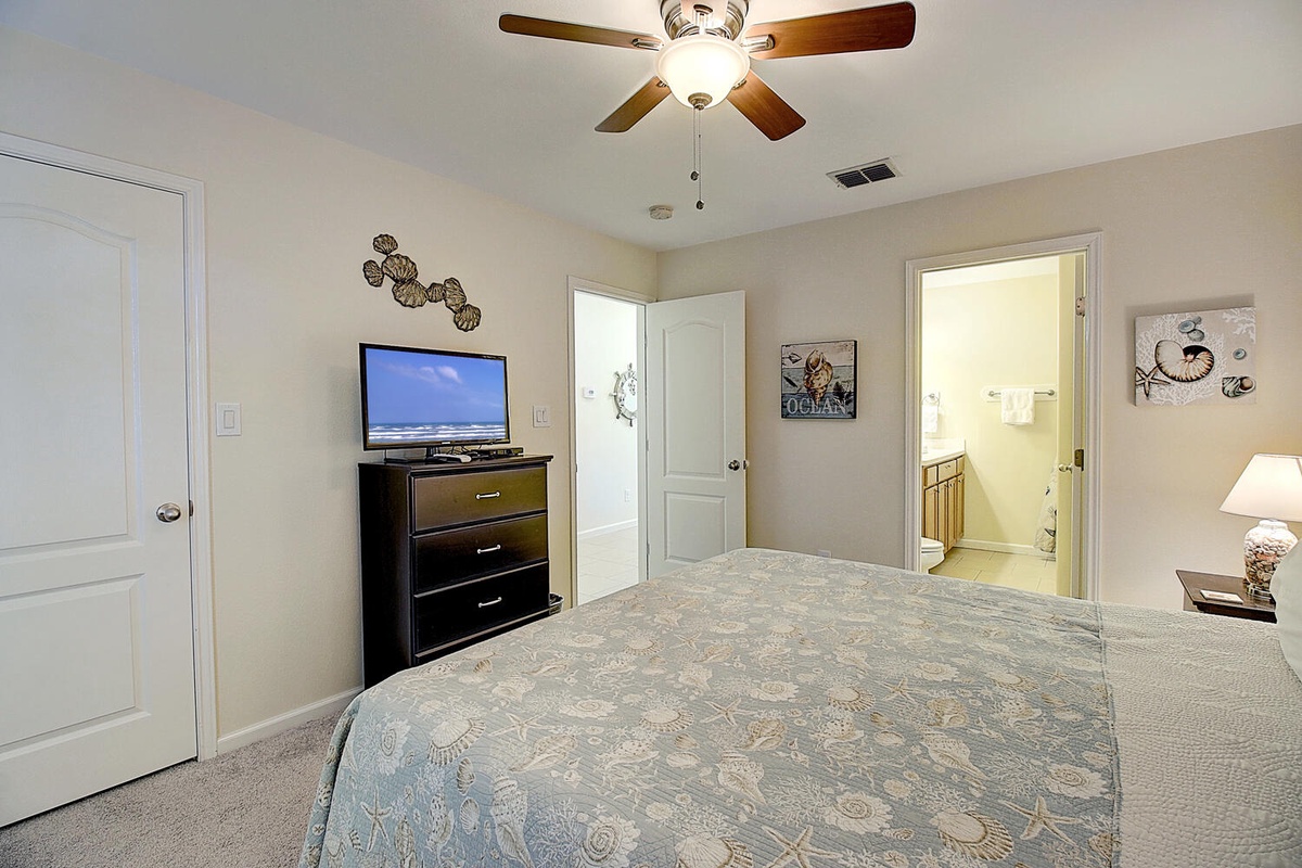 Relax in your comfortable bedroom with ceiling fan, flat-screen TV, and private bathroom access for ultimate convenience.