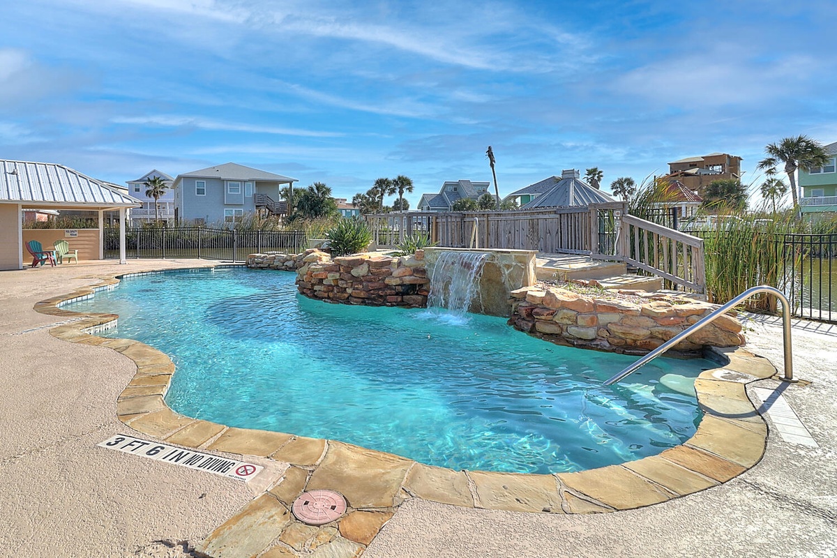 Stunning resort-style pool with waterfall feature creates your perfect tropical escape in this coastal community setting.