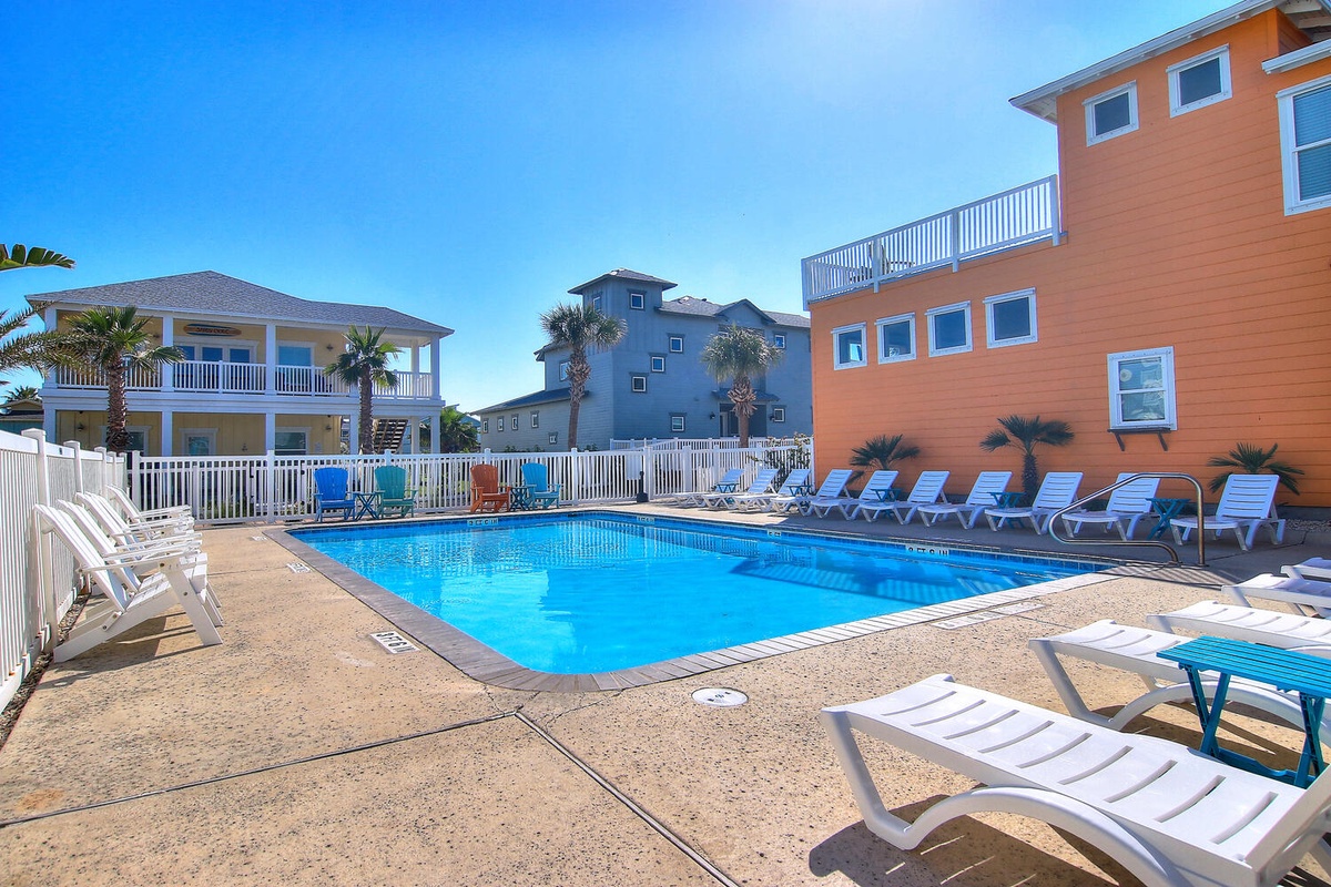 Bright coastal community with vibrant beach houses surrounding a sparkling pool area.