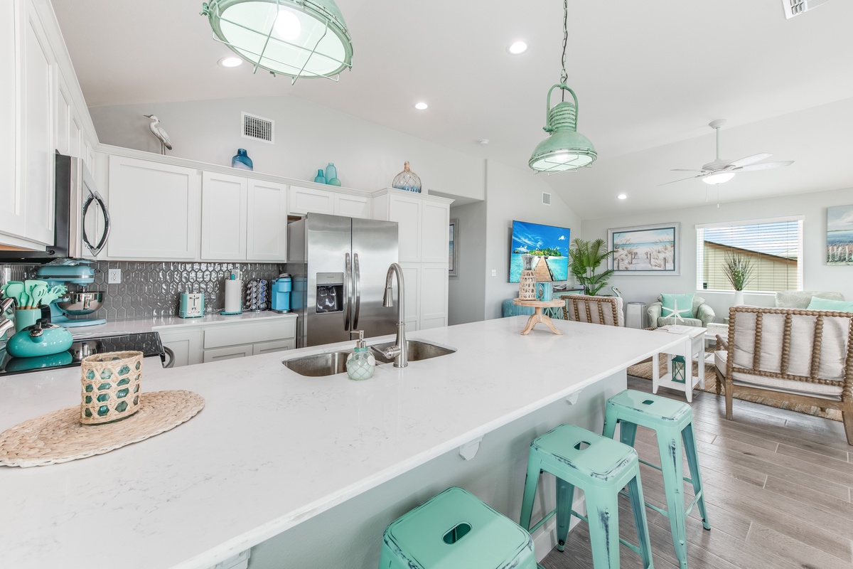 Your modern coastal kitchen features bright turquoise accents, spacious counters, and an open layout perfect for creating memorable meals.
