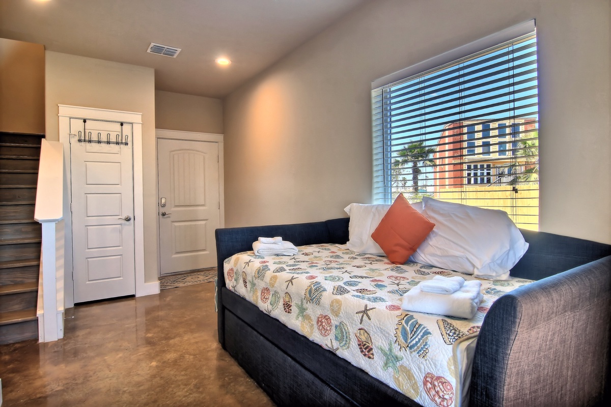 Relax on your cozy daybed with fresh linens and colorful pillows, while city views stream through the window blinds.