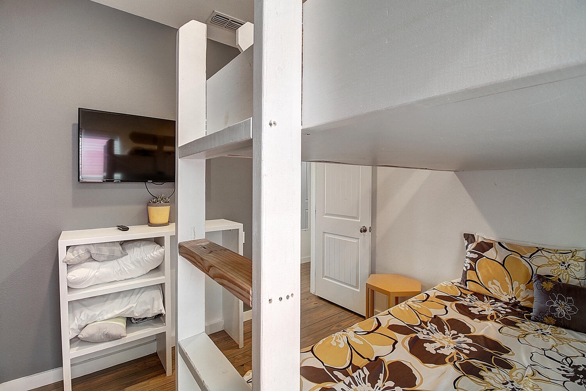 Your cozy bunk bed setup features fresh linens, a wall-mounted TV for relaxation, and clever storage for a comfortable stay.