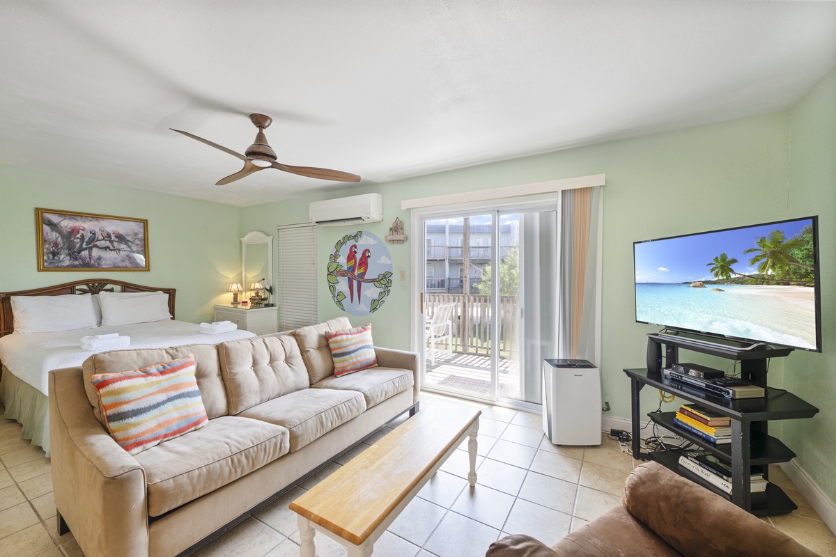 Your tropical retreat combines bedroom and living space with AC comfort, ceiling fan, and entertainment center for ultimate relaxation.
