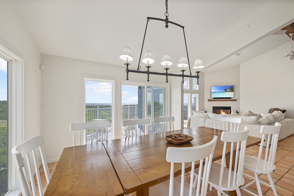 Gather around your rustic dining table under elegant pendant lighting, with panoramic windows framing stunning views.
