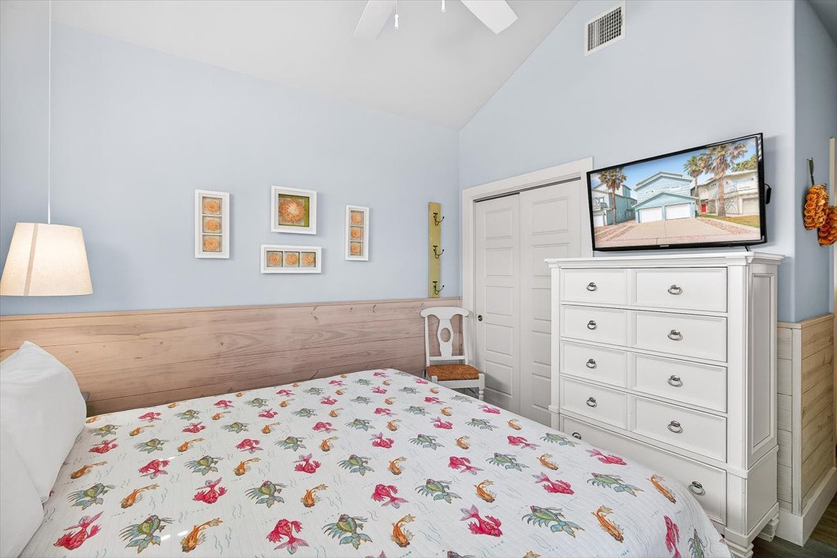 Relax in your cozy bedroom with vaulted ceilings, warm wood accents, and charming coastal touches that create the perfect seaside retreat.