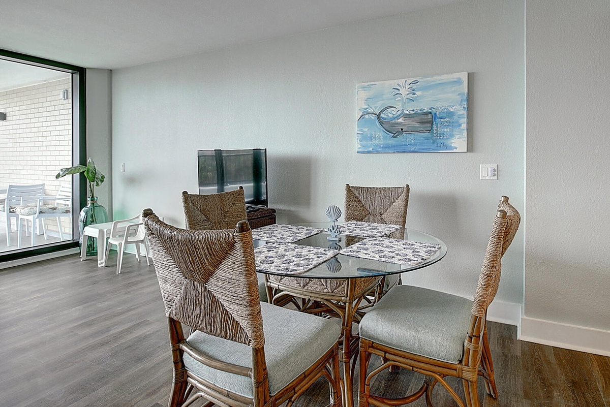 Gather around your stylish dining table, where woven chairs and coastal artwork create the perfect spot for memorable meals together.