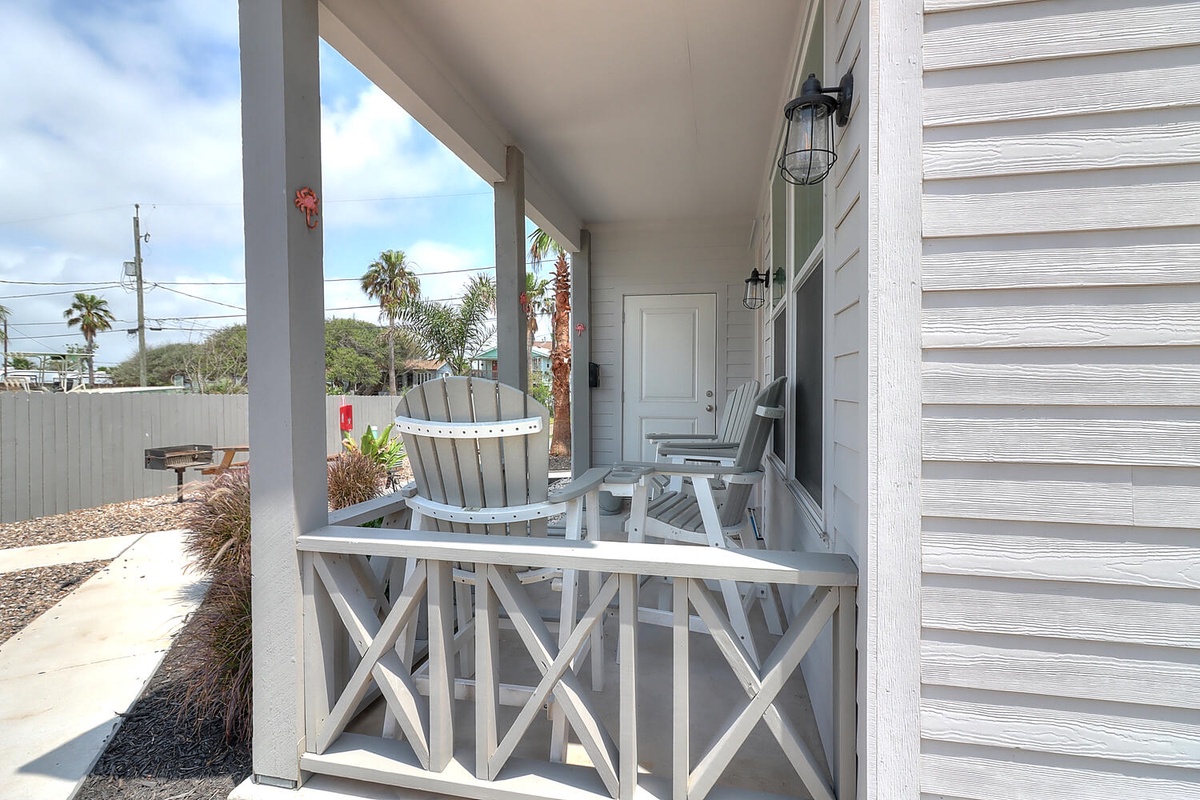 Your private covered porch offers coastal charm with comfortable seating and tropical views.