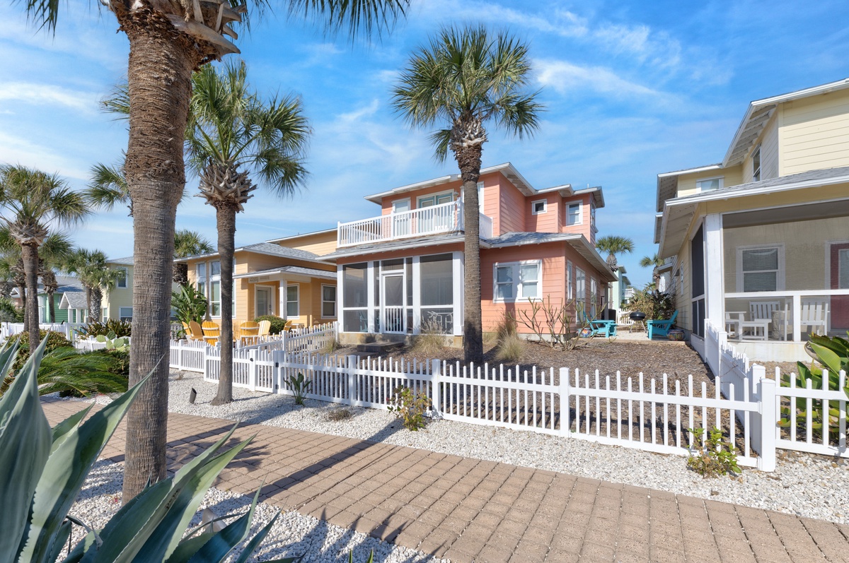 Bright coastal homes with palm trees create your perfect beach getaway setting in this charming neighborhood.