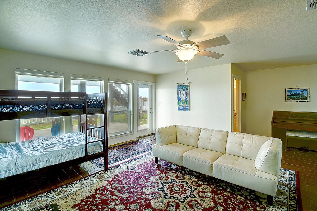 Relax in your spacious living area with plush sofa and kids' bunk beds—perfect for family comfort.