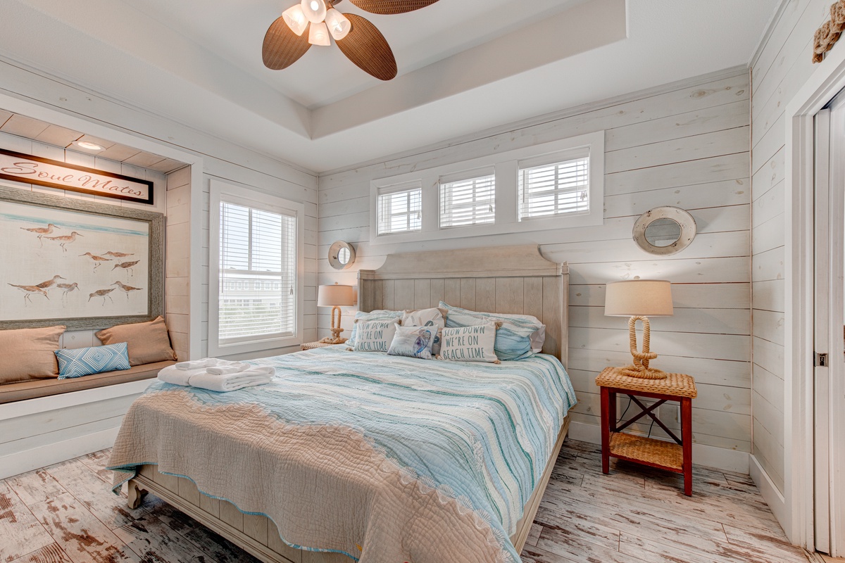 Drift off to sleep in this coastal-inspired bedroom with shiplap walls and ocean-themed decor creating your perfect seaside retreat.