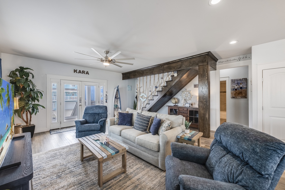 Unwind in your spacious living room with plush seating, rustic wood beams, and abundant natural light streaming through French doors.