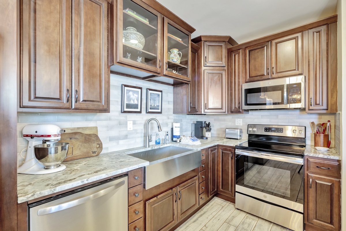 Step into your fully equipped kitchen featuring rich wood cabinetry, granite countertops, and stainless steel appliances ready for your culinary adventures.