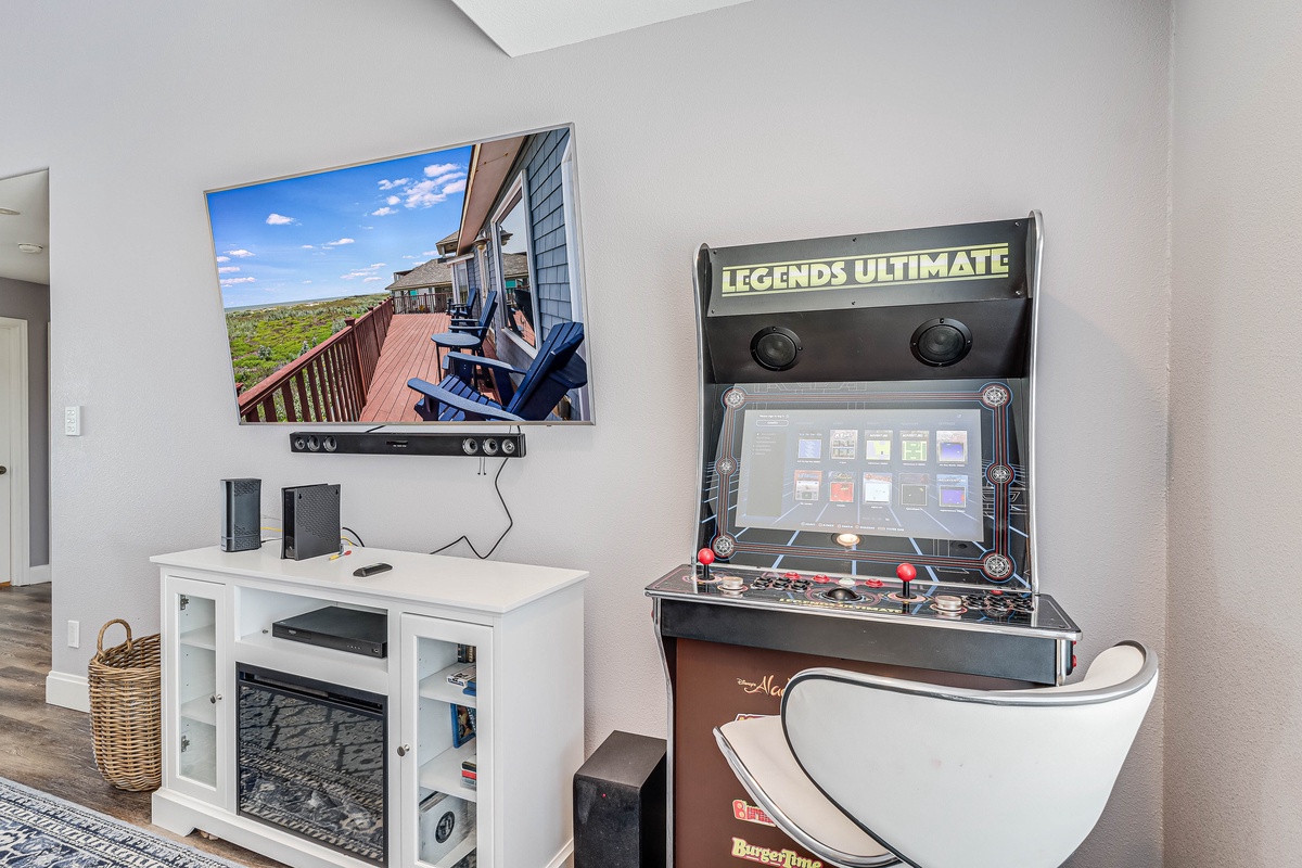 Your entertainment corner awaits with arcade gaming and cozy fireplace ambiance for perfect evening relaxation.