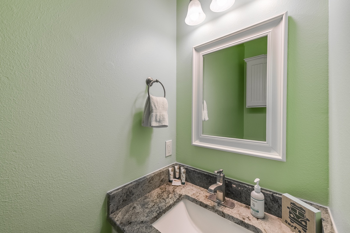 Freshen up in your private powder room, featuring a granite vanity and cheerful green accent wall that adds warmth to your morning routine.