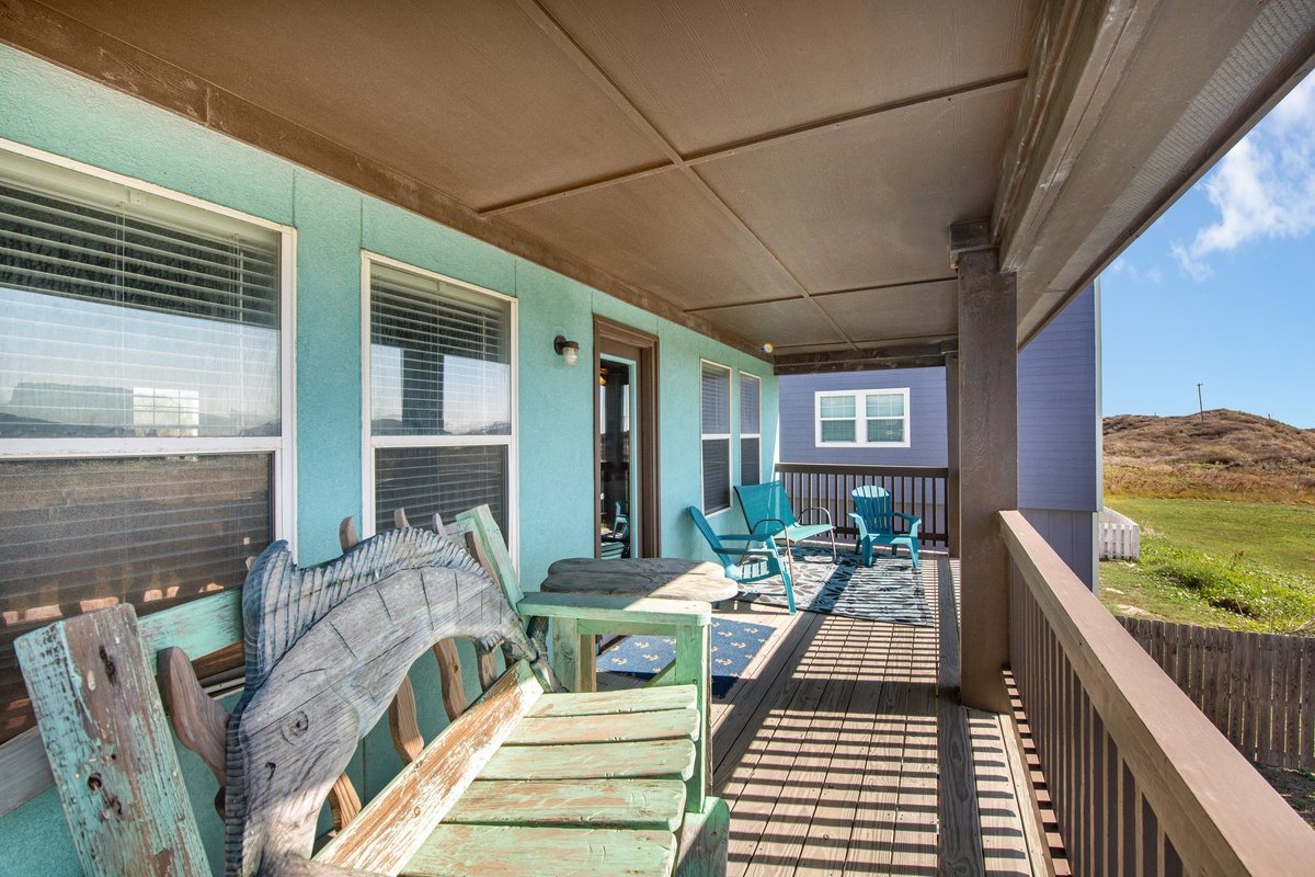 Unwind on your spacious covered deck with cozy seating and coastal views stretching to rolling hills beyond.