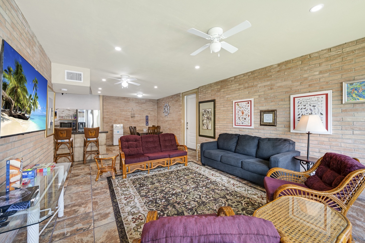 Relax in your spacious living area with comfortable seating, ceiling fans for cool breezes, and easy access to the kitchen—perfect for unwinding after a day of adventure.