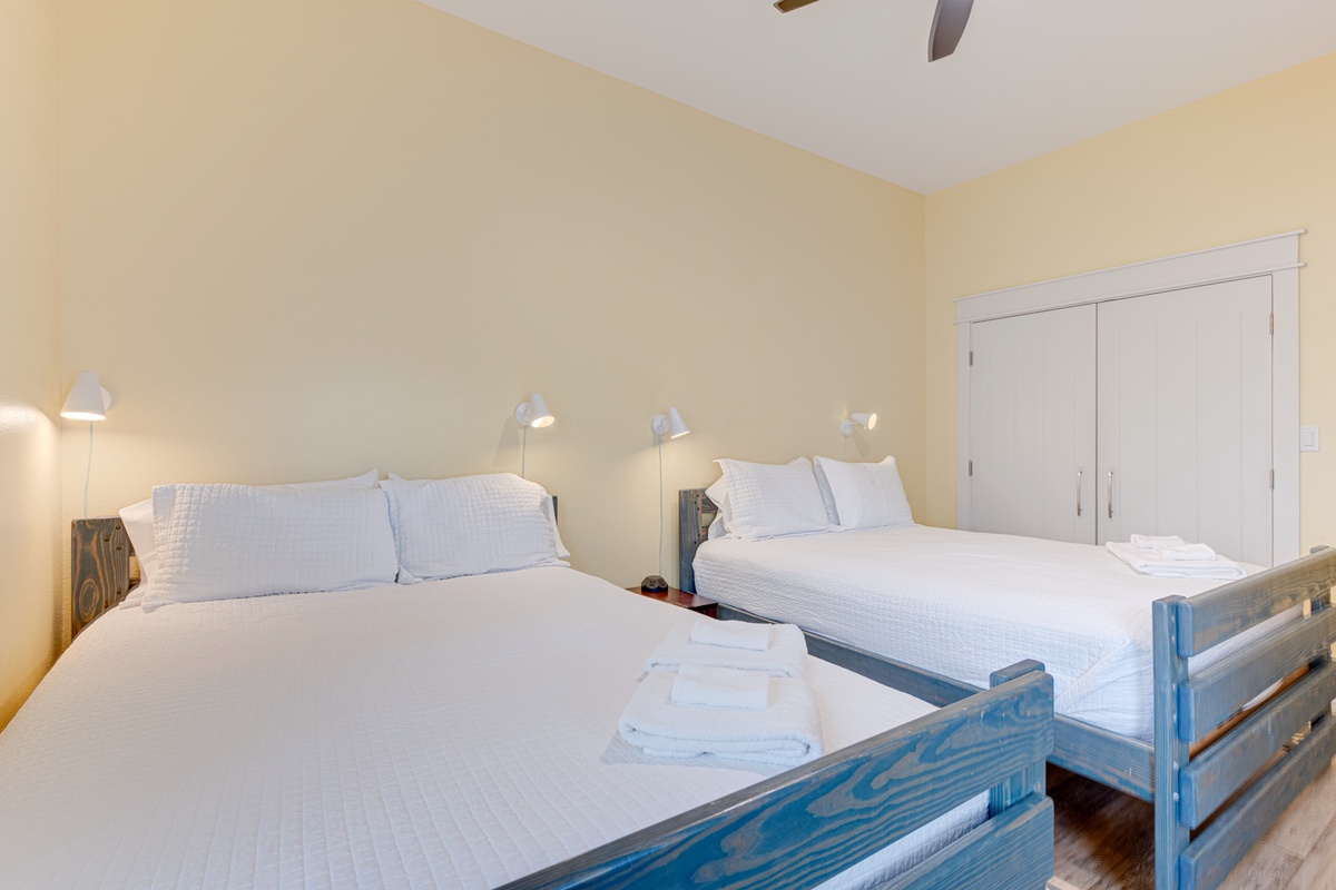Drift off to sleep in your cozy twin bedroom with crisp white linens and gentle reading lights for late-night comfort.