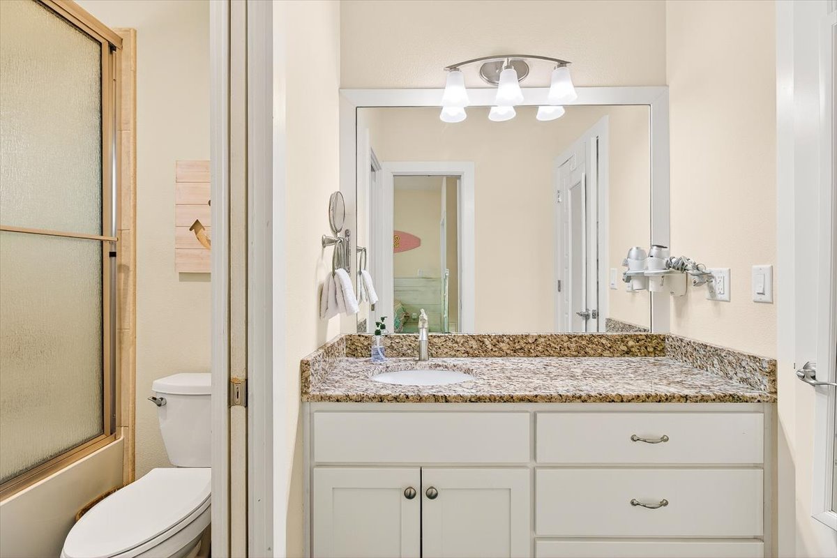 Your private bathroom features elegant granite countertops, crisp white cabinetry, and modern lighting for your morning routines.