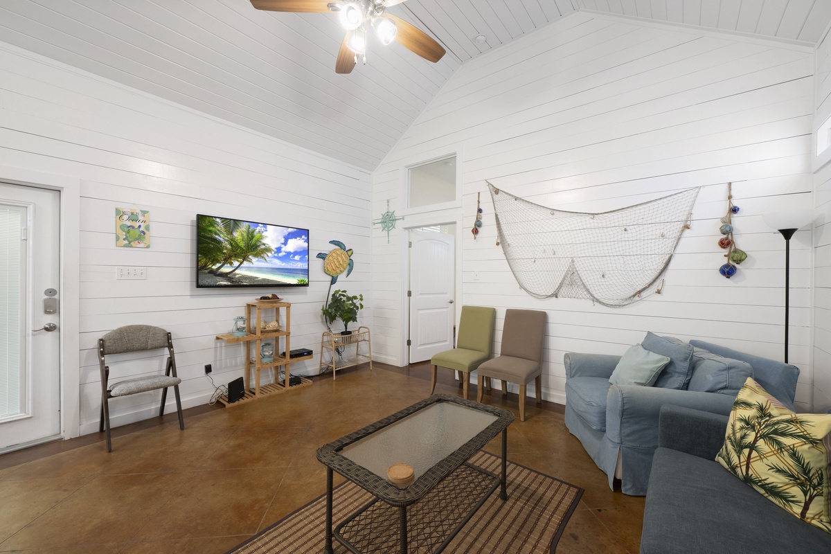 Unwind in your bright coastal living room, where shiplap walls and high ceilings create a serene, beach-inspired retreat. Perfect for relaxing with loved ones after sun-soaked adventures.