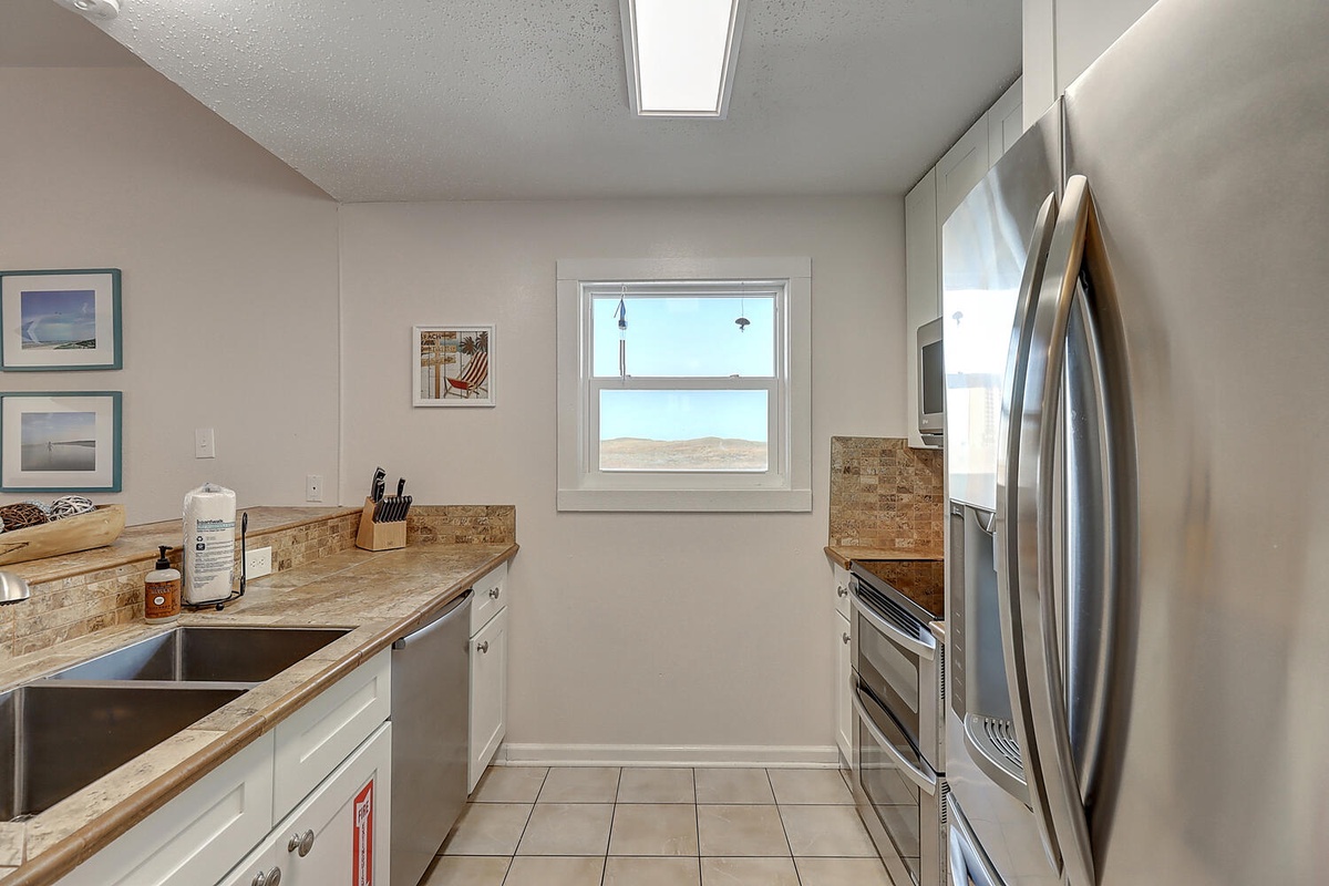 Your fully equipped kitchen awaits with granite counters, stainless appliances, and a skylight flooding the space with natural light.